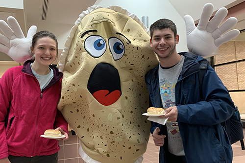 two students flanking an insomnia cookie mascot