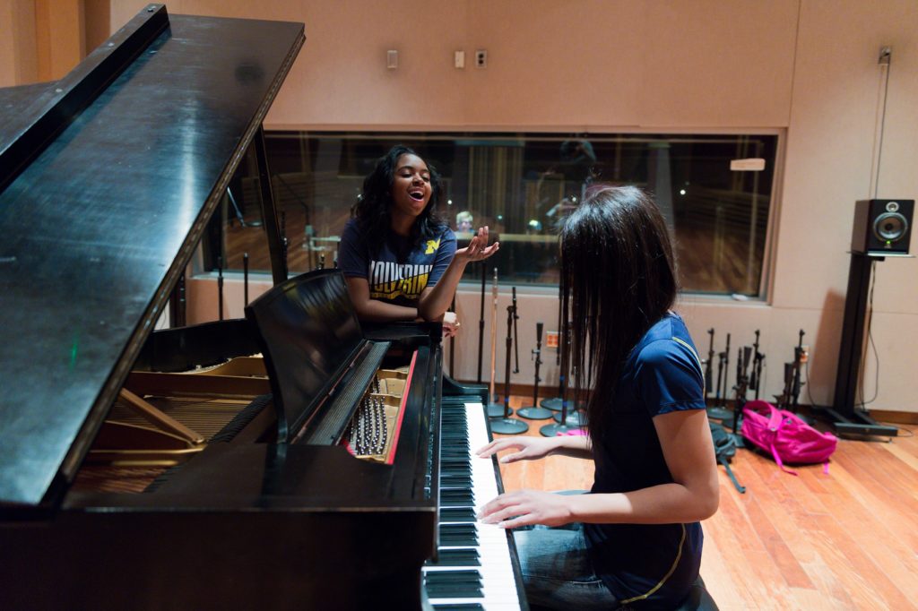 Students playing piano and singing