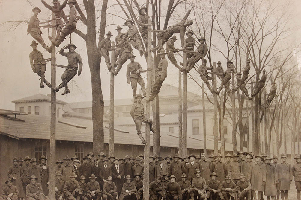 Students, instructors, and officers climb telephone poles 