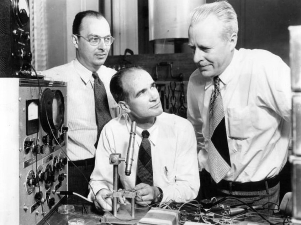 vintage photo of scientists around a transistor