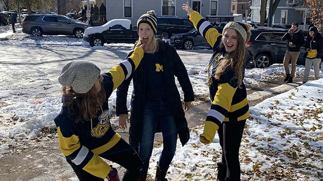 3 students in Michigan gear on gameday