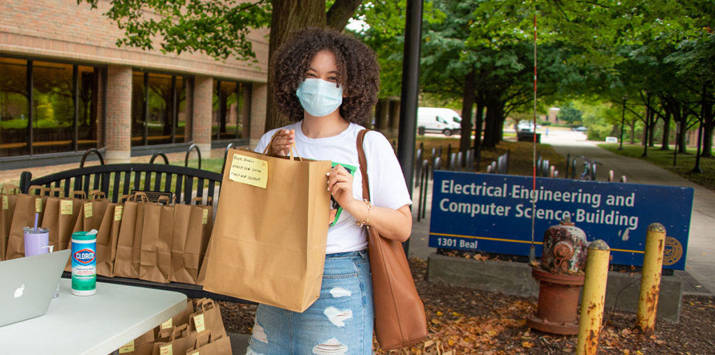 Student with a bag of lab supplies
