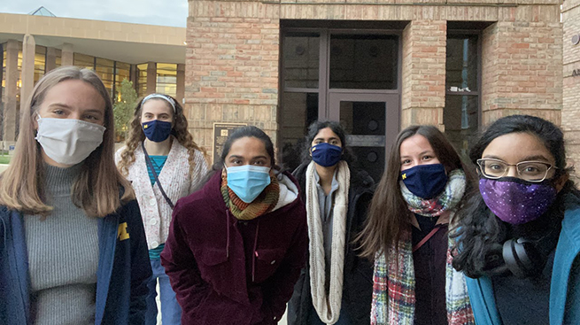 Group of women from WECE wearing pandemic masks outside on north campus