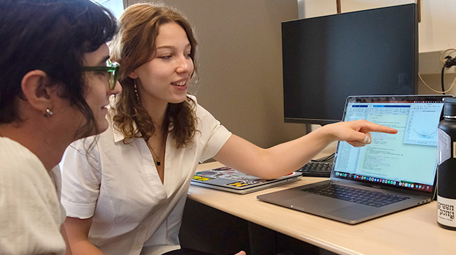 Two students discussing test results shown on a computer.